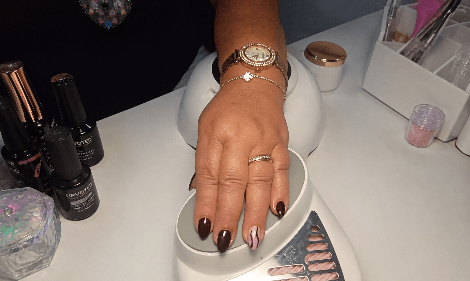 Unhas em tom bordeaux com detalhe decorativo